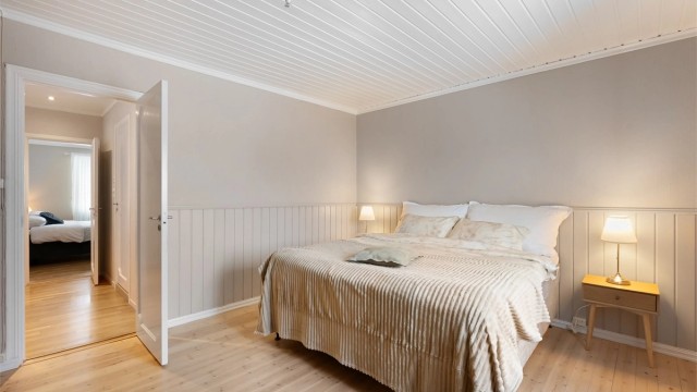 Rommet har originale gulvbord av tre og vegger med brystningspanel.