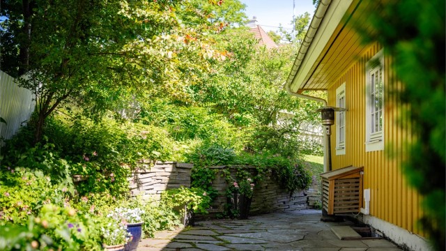 Den frodige hagen skaper en grønn og skjermet ramme rundt boligen, med hyggelige uteområder og god plass til rekreasjon.