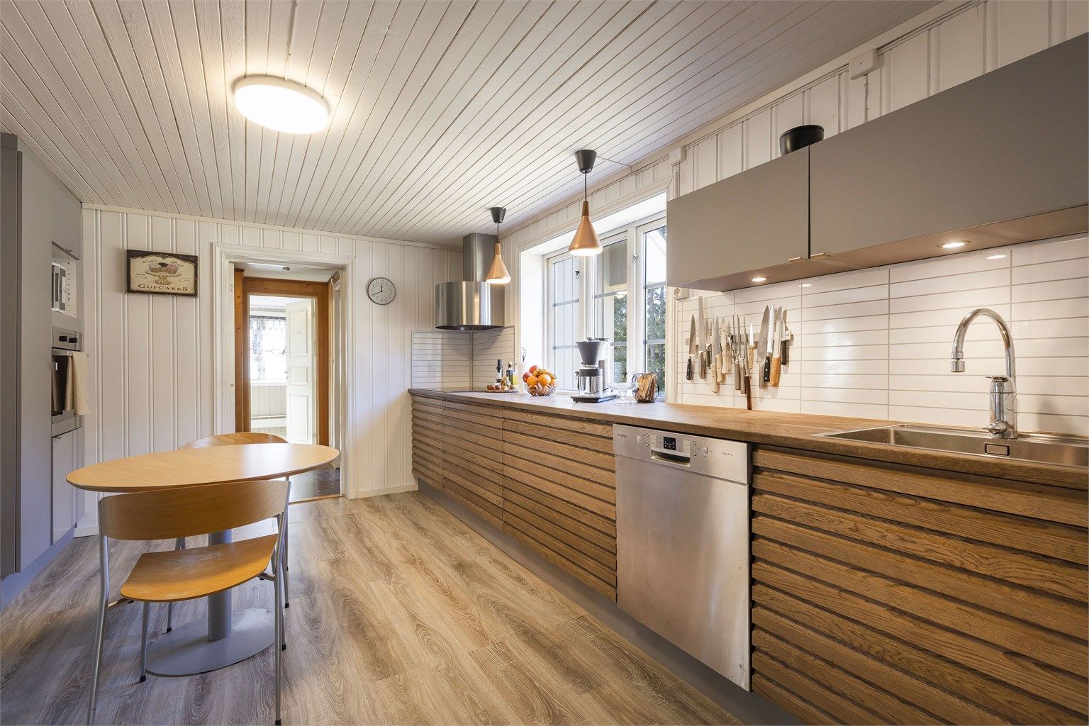 Kjøkkenet er blant annet innredet med benkeplate og fronter av heltre, samt integrert oppvaskmaskin og komfyr.