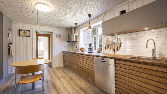 Kjøkkenet er blant annet innredet med benkeplate og fronter av heltre, samt integrert oppvaskmaskin og komfyr.