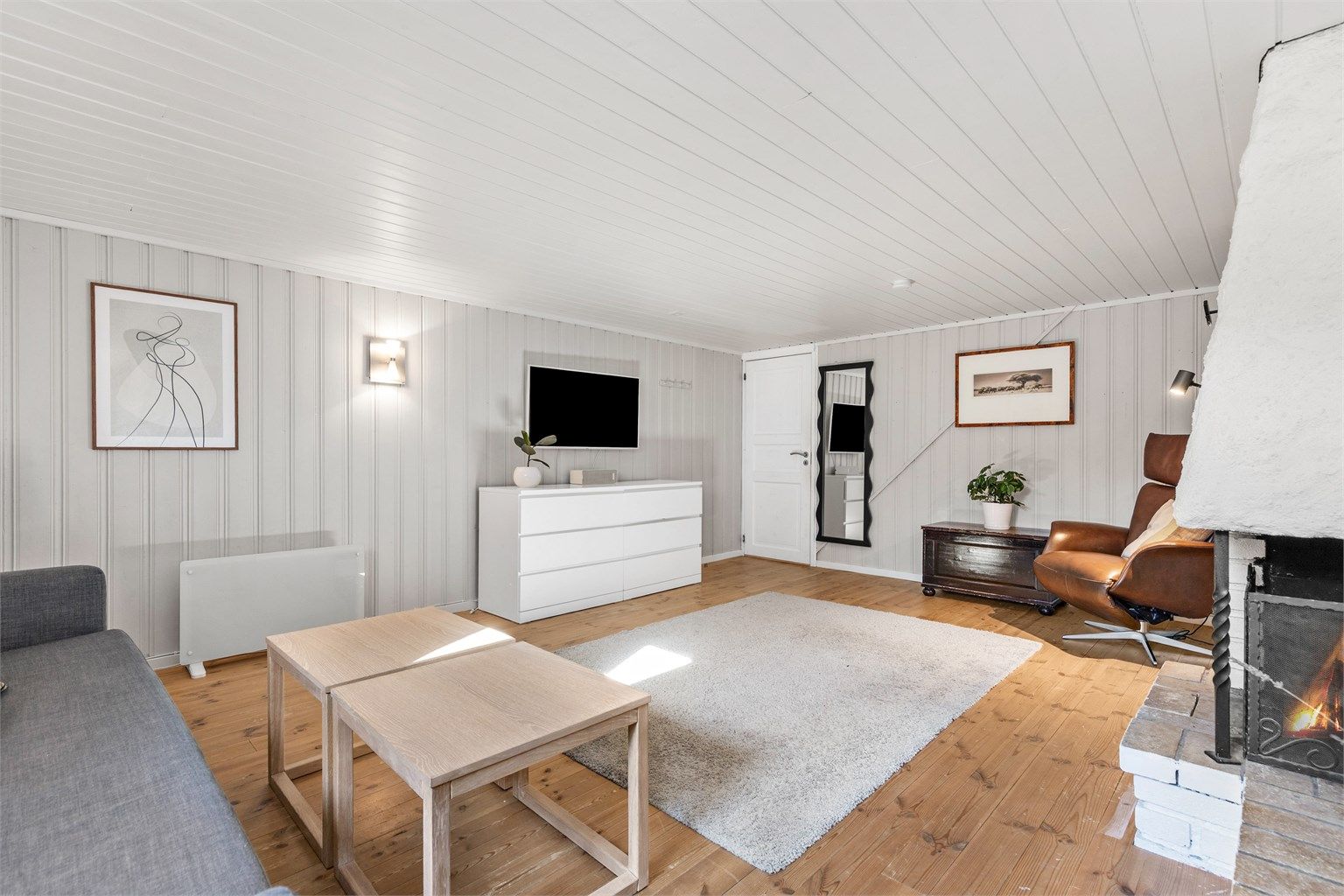 Kjellerstuen med åpen peis. Rommet er ikke godkjent for varig opphold.