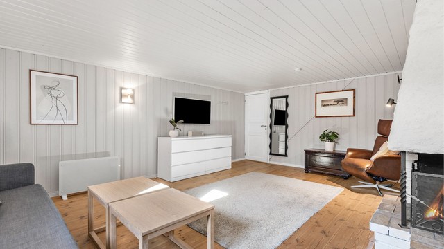 Kjellerstuen med åpen peis. Rommet er ikke godkjent for varig opphold.