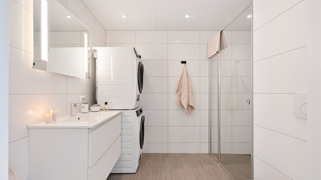 Badet er flott helfliset med fine fliser på gulv og på vegg. Det er spotter i tak som gjør badet ekstra lyst og det er i tillegg speil på vegg over servant med innfelt lys.