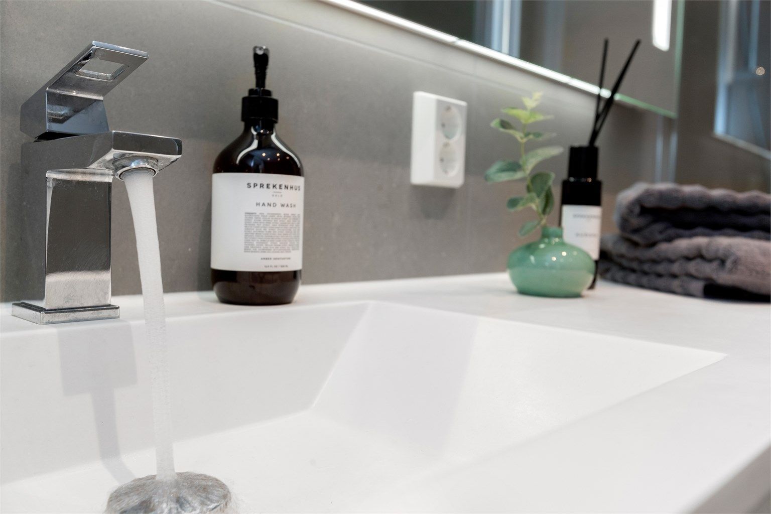 Servantinnredning med gode oppbevaringsmuligheter og speil med integrert belysning.