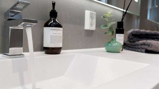 Servantinnredning med gode oppbevaringsmuligheter og speil med integrert belysning.