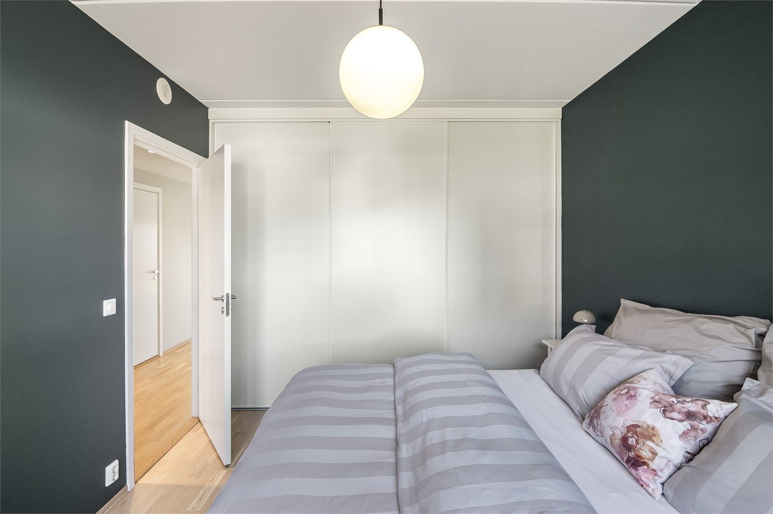 En hel vegg er dedikert til oppbevaring med en stor skyvedørsgarderobe.