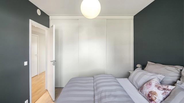 En hel vegg er dedikert til oppbevaring med en stor skyvedørsgarderobe.