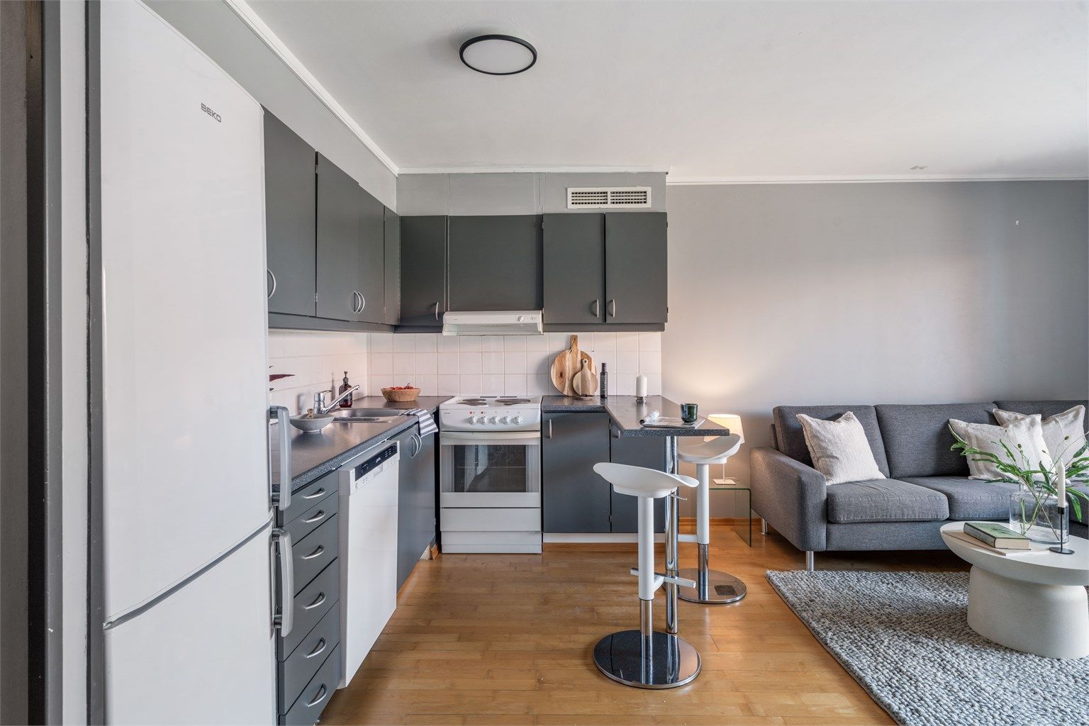 Kjøkkenet er praktisk innredet med laminatbenkeplate og malte, slette fronter.