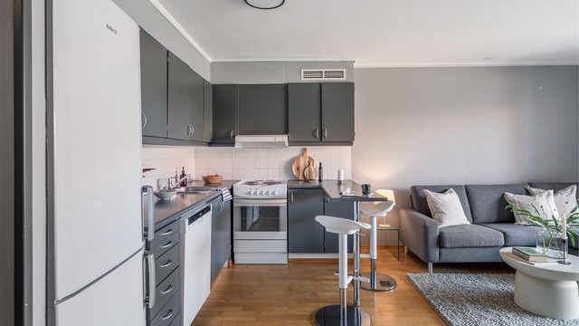 Kjøkkenet er praktisk innredet med laminatbenkeplate og malte, slette fronter.