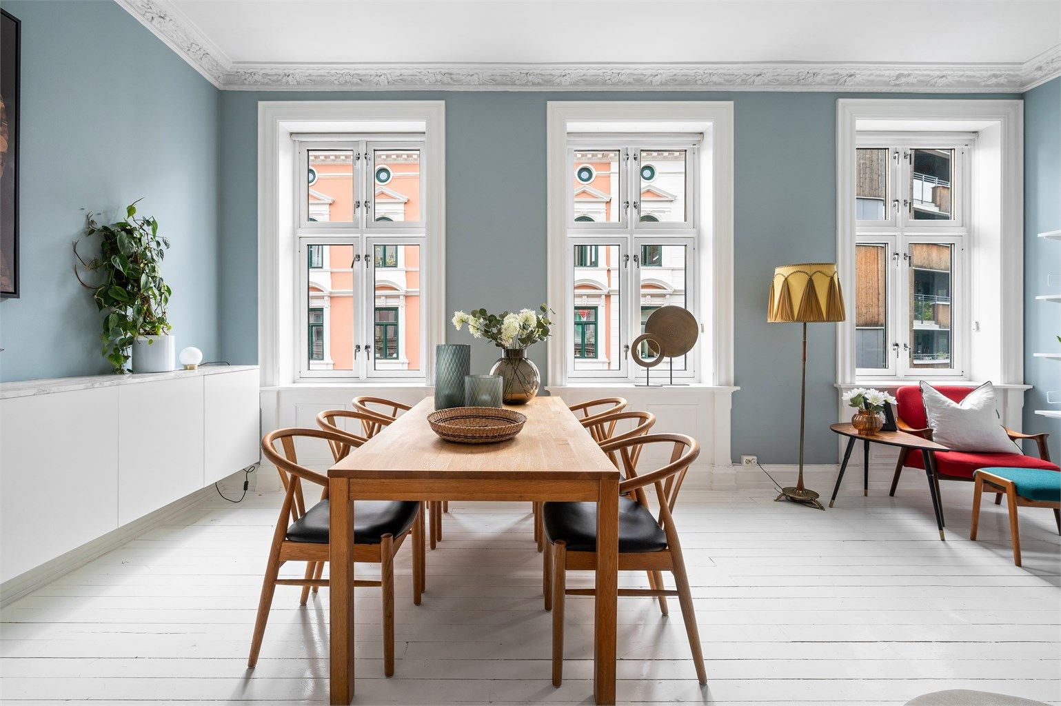 Stuen har, som resten av boligen, store vindusflater med dype karmer som slipper inn rikelig med lys gjennom dagen.
