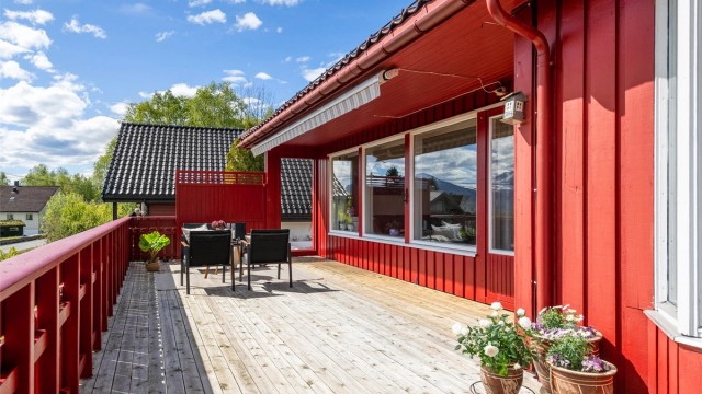 Terrassen har trerekkverk og er et flott sted for å nyte utelivet.