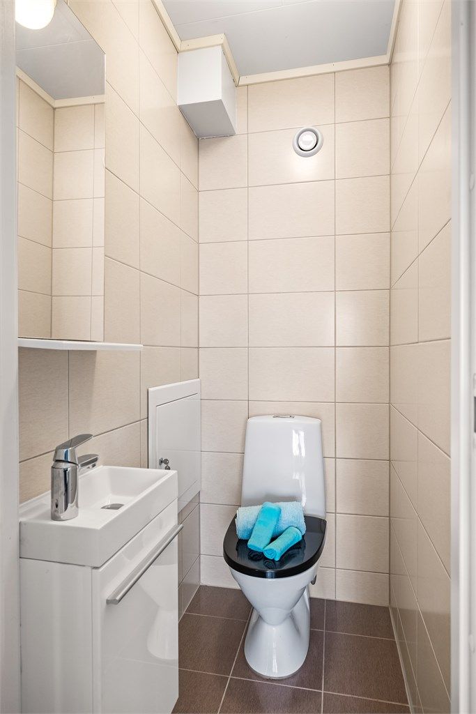 Separat og praktisk toalettrom er etablert ved siden av badet. Rommet er innredet med servantmøbel og speil.