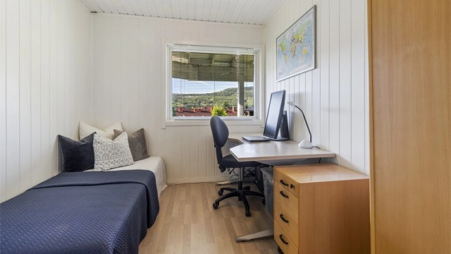 Soverom 2 med laminat på gulv, panelplater på vegger og malt panel i himling.