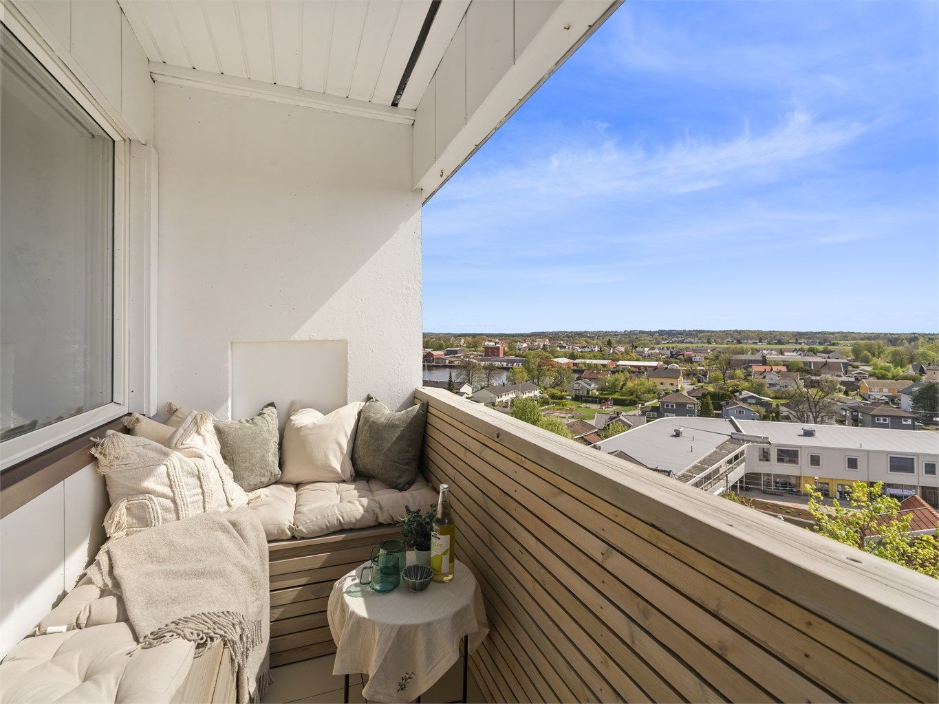 Balkongen er nylig beiset og malt, plastfliser er lagt på gulvet og lekter skrudd på rekkverket.