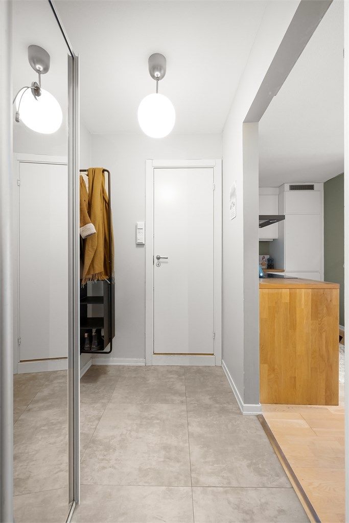 Entré med garderobeskap med speil og adkomst til bad samt stue/kjøkken.