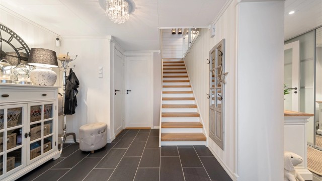 En solid tretrapp binder de to etasjene sammen på en elegant måte