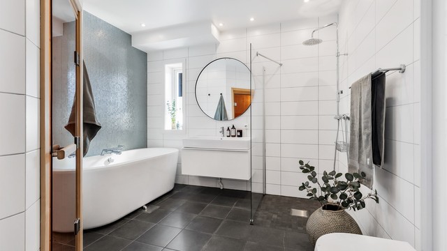 Baderom med flislagt gulv med varme og flislagte vegger. Nedsenket himling med downlights. Vegghengt servantskap i slett utførelse. Ovenpåliggende servant med ett-greps armatur. Dusjsone med skillevegg i glass. Dusjarmatur tilkoblet hånddusj og regndusj.