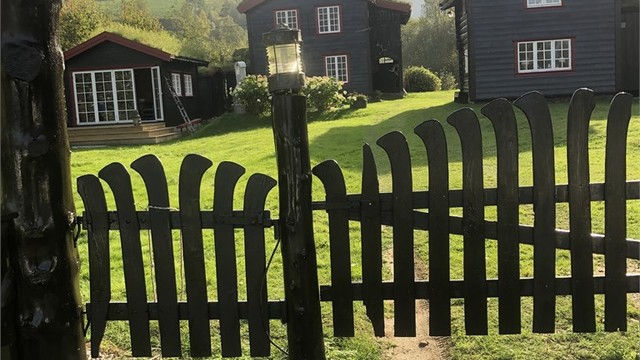 En sjarmerende port ønsker deg velkommen inn på tunet.