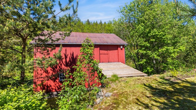 Uthuset har stående trekledning og tak tekket med metallplater.