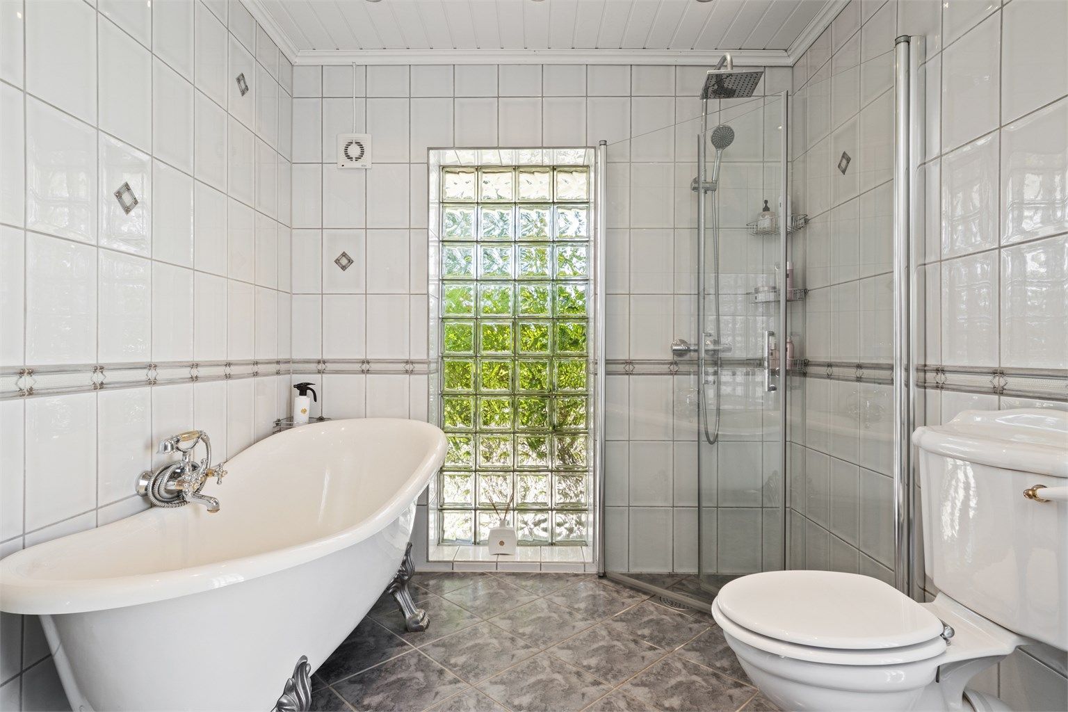 Rommet er familievennlig innredet med både badekar og et dusjhjørne. Badekaret har løveføtter og nostalgisk kran, mens dusjhjørnet har regnfallsdusj, hånddusj og innfellbare glassdører.