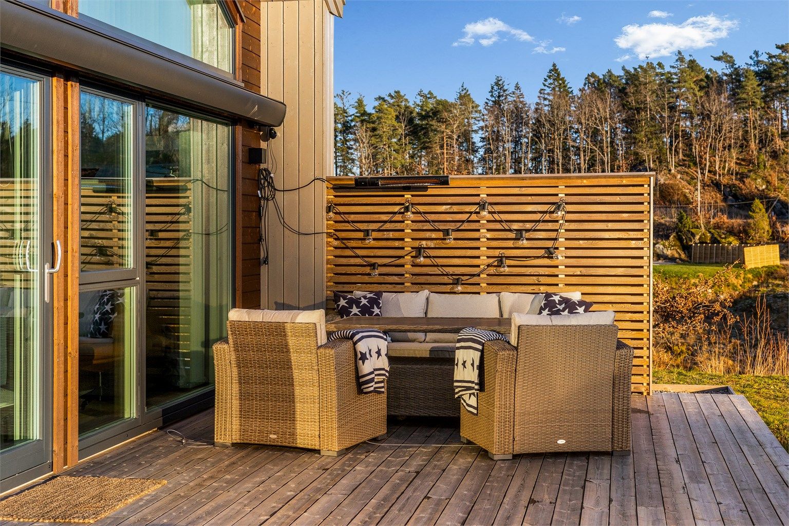 UTEPLASS MED EKSTRA DIMENSJON: I hjørnet utenfor stuen er det laget en skjermet uteplass. Den er møblert med lave lounge-sofaer. Den store markisen gir sitteplassen en ekstra dimensjon.