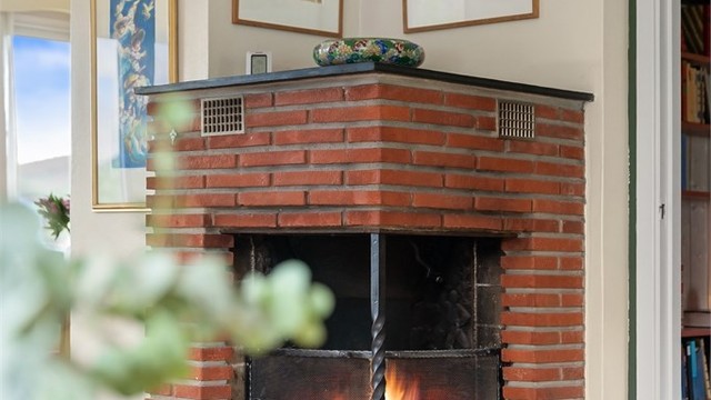 Peisen i stuen er et sentralt samlingspunkt for varme og hygge.