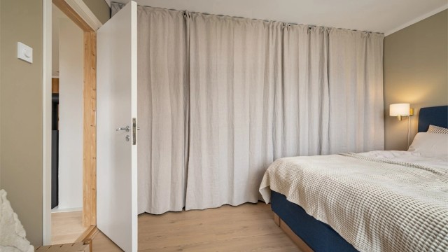 Rommet er utstyrt med en romslig garderobe med god lagringskapasitet, skjermet med takhengt gardin