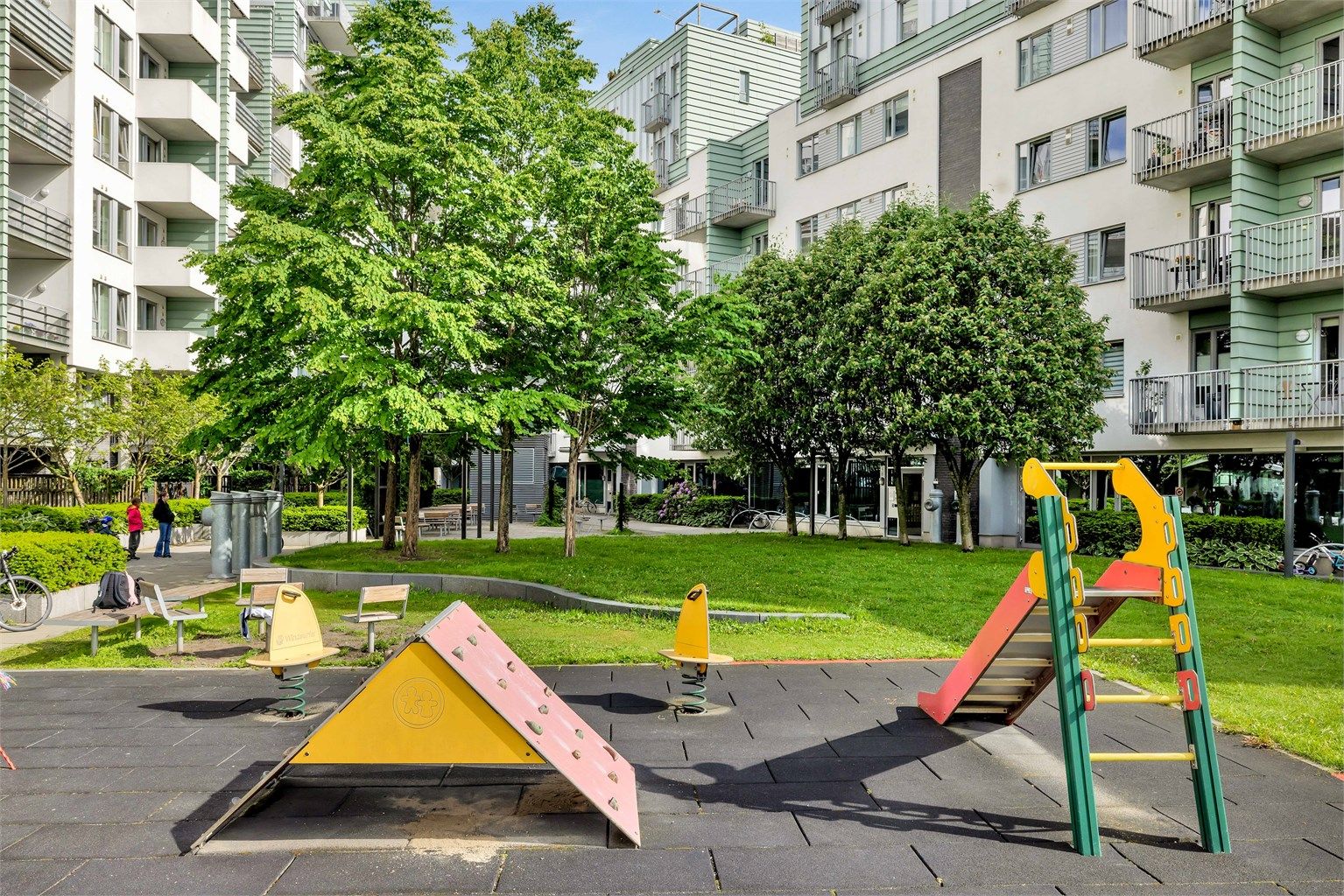 Fellesområdet er opparbeidet med blant annet belegningsstein, lekeplass, sittegrupper, plenarealer og andre forskjellige beplantninger.