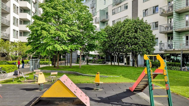 Fellesområdet er opparbeidet med blant annet belegningsstein, lekeplass, sittegrupper, plenarealer og andre forskjellige beplantninger.