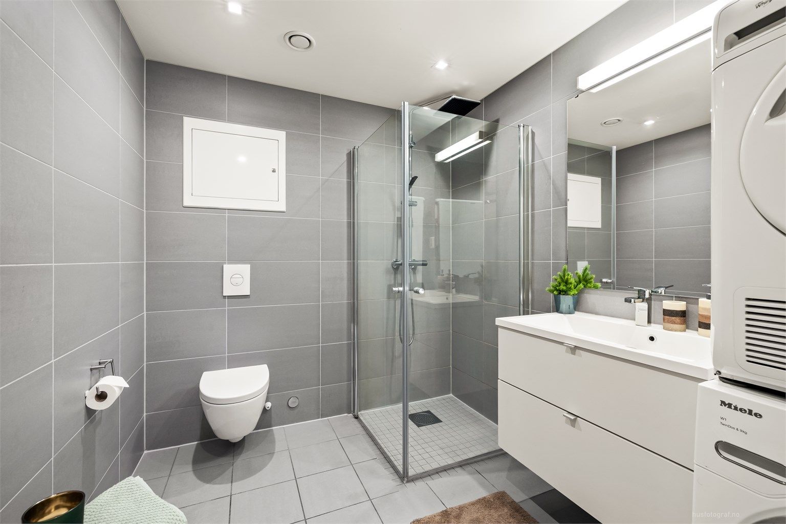 Lyst og pent bad med dusjhjørne som har regnfallsdusj