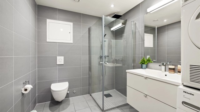 Lyst og pent bad med dusjhjørne som har regnfallsdusj