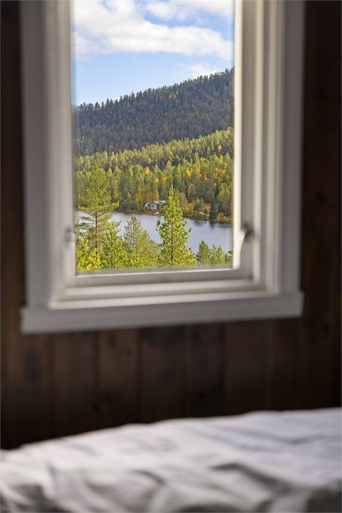 Utsyn fra soverommet mot vannet og de omkringliggende skogsåsene.
