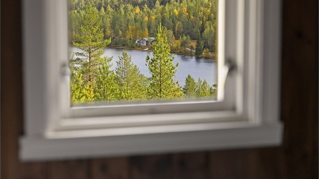 Utsyn fra soverommet mot vannet og de omkringliggende skogsåsene.