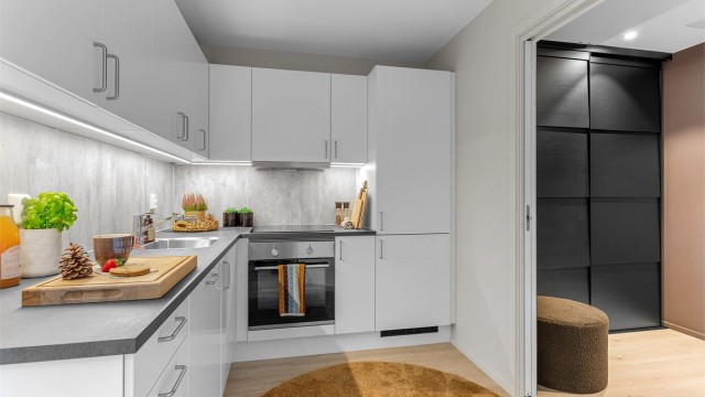 Fint kjøkken med innredning med glatte fronter og benkeplate med laminert overflate med kjøkkenvask