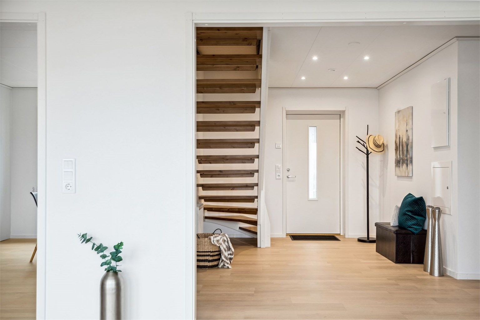 Lysrik og stilren entré med downlights som gir et godt førsteinntrykk til boligen. Her er det plass til garderobeløsning. 