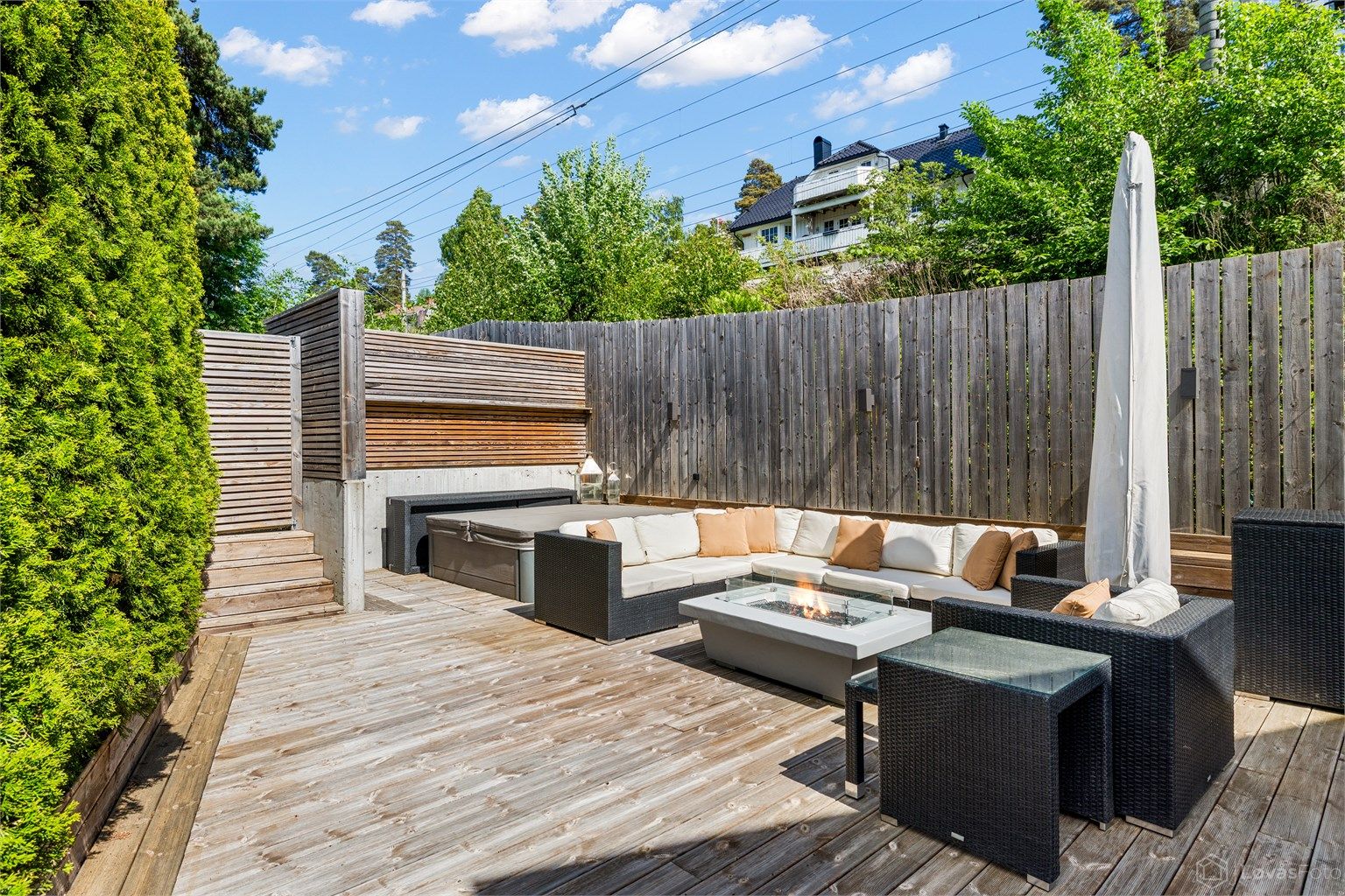 Stor og skjermet terrasse med jacuzzi som vil følge boligen. Møblene og parasollen på terrassen vil også medfølge