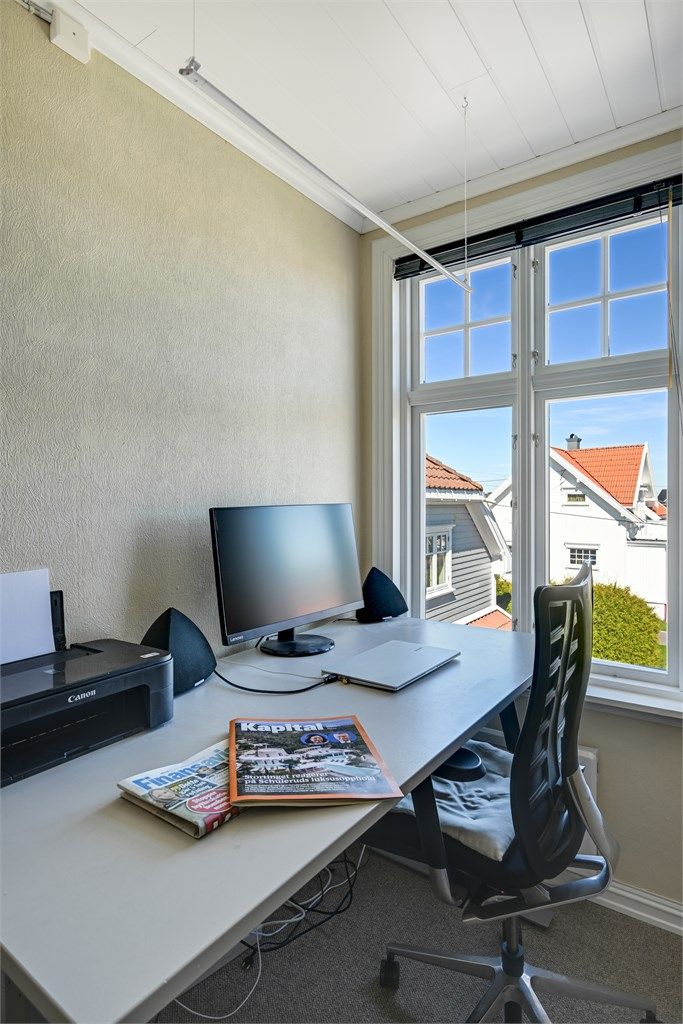En lys og fin arbeidsplass ved vinduet.