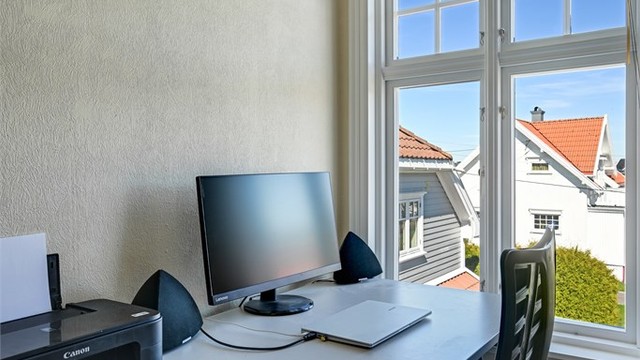 En lys og fin arbeidsplass ved vinduet.