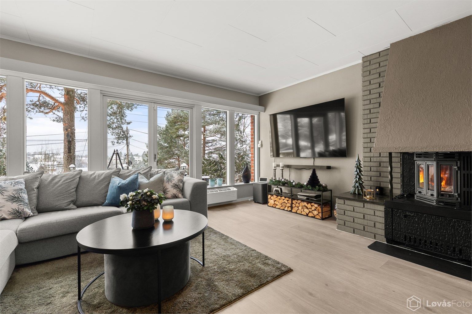 Romslig og kombinert stue og spisestue med store vindusflater og peis. Utgang fra rommet til uteområdet.