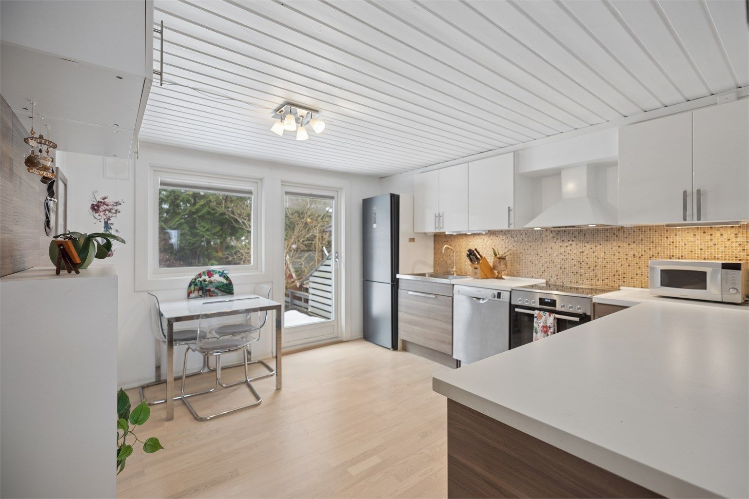 Det er god skap- og benkeplass, og kjøkkenet har også romslig plass til spisebord med et hyggelig utsyn mot hagen. Dette gir en lys og trivelig spiseplass med fin kontakt mellom inne- og uteområdet.