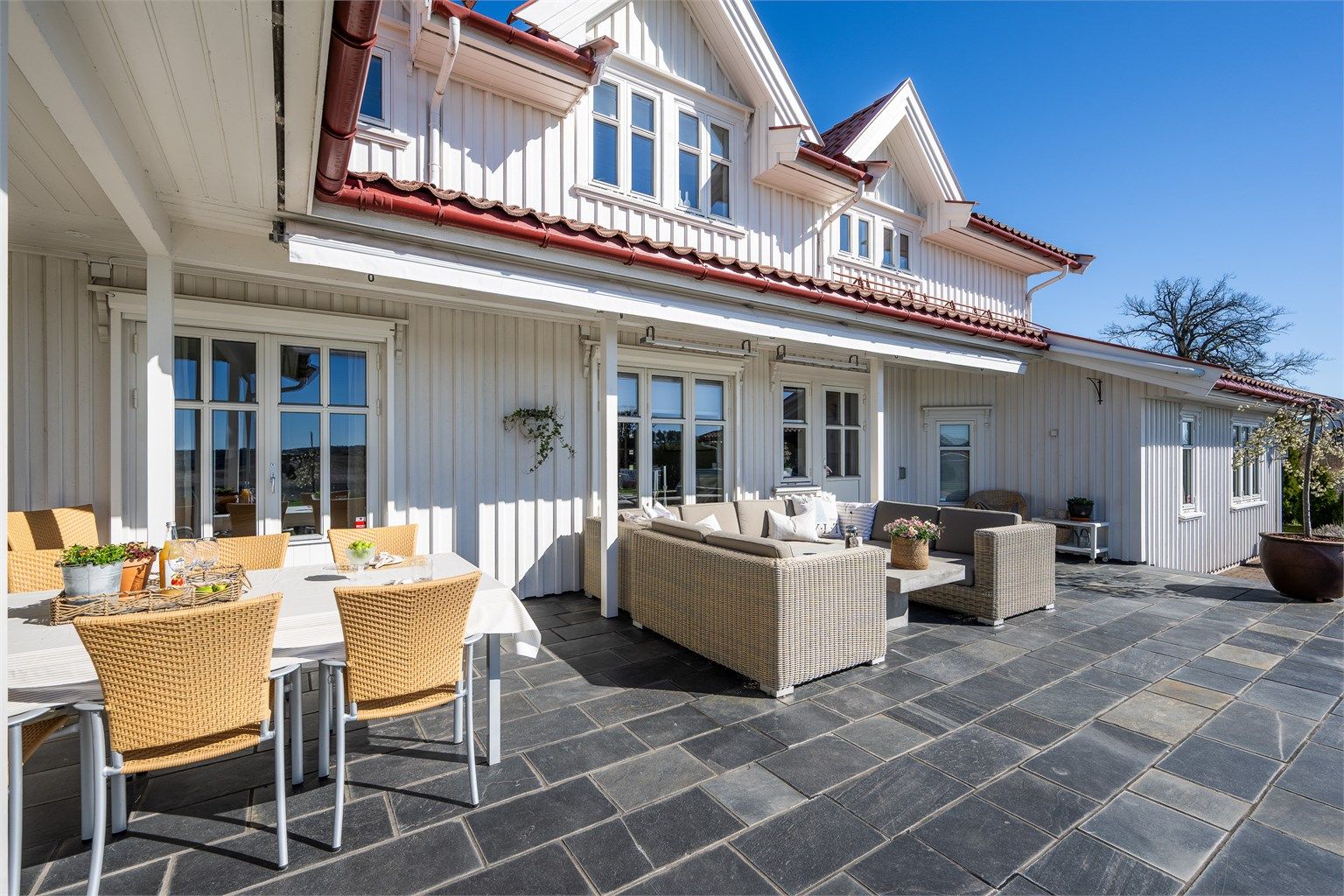 Terrassen er delvis overbygget og har skiferflis på støpt betongplate.