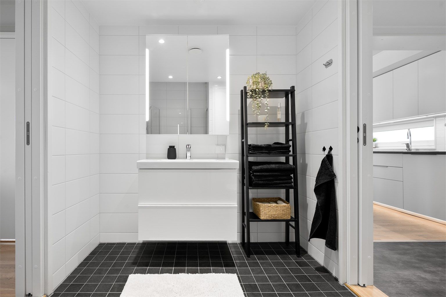 Badet er innredet med vegghengt servantskap med skuffer og ovenpåliggende servant med ett-greps armatur. Over servant er det speilskap med belysning samt praktiske stikkontakter.