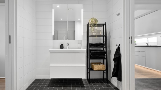 Badet er innredet med vegghengt servantskap med skuffer og ovenpåliggende servant med ett-greps armatur. Over servant er det speilskap med belysning samt praktiske stikkontakter.