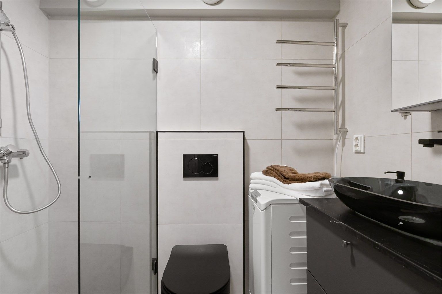 Badet er fra 2022, med flislagt gulv med varme og opplegg for vaskemaskin.