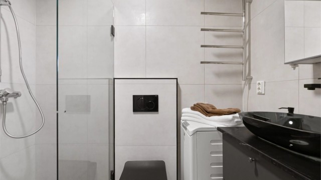 Badet er fra 2022, med flislagt gulv med varme og opplegg for vaskemaskin.