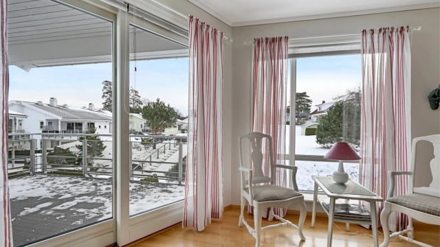 De store vindusflatene og døren ut mot balkongen slipper inn rikelig med naturlig lys og gir rommet en lys og trivelig stemning.