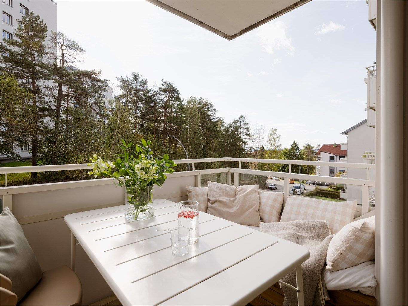 Den sydvendte balkongen på 7m² har blant annet en plassbygget sofa som utnytter plassen optimalt og herlig utsyn over tretoppene