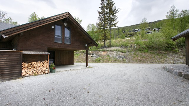 Gruset gårdsplass med gode parkeringsmuligheter rett utenfor hytta.
