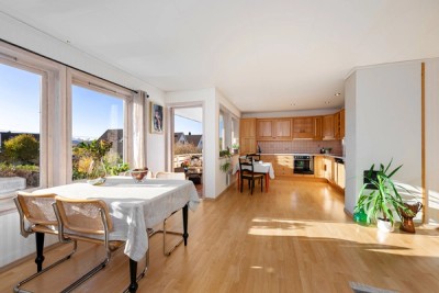 Stue og kjøkken i åpen løsning og med godt med naturlig lysinnslipp fra vinduer