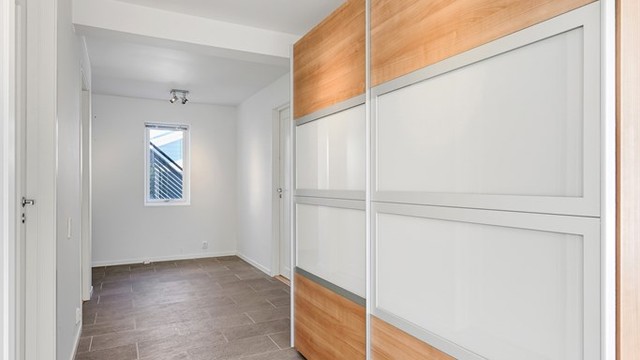 Stor skyvedørsgarderobe er plassert i gangen utenfor soverommene